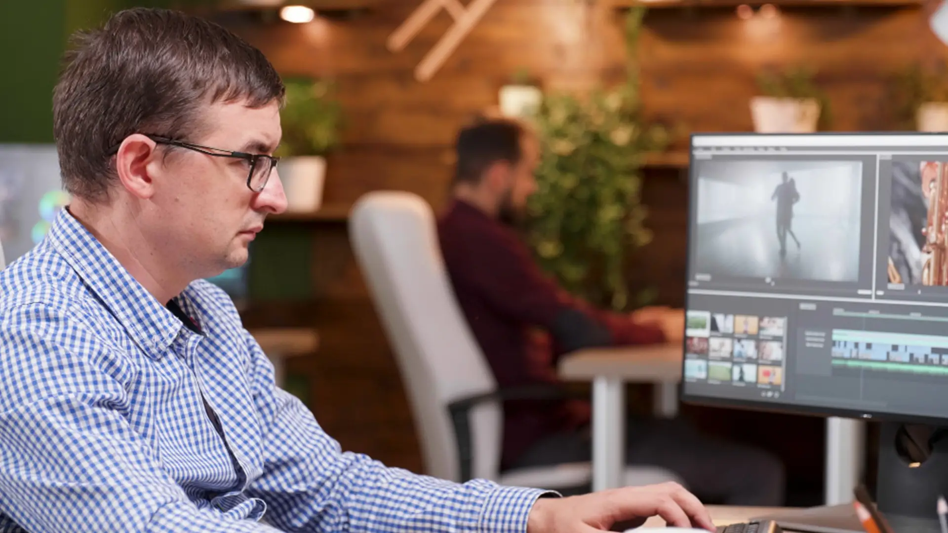 Personne qui monte une vidéo sur un ordinateur avec un logiciel de montage vidéo professionnel